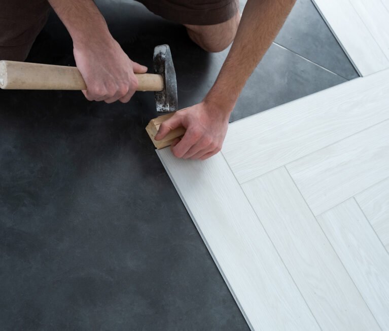 A man lays a quartz laminate on the floor. Renovation of premises. Installation of Modern flooring