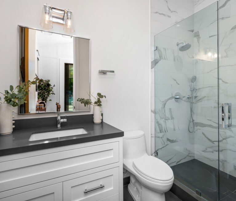 A white toilet, walk-in shower, and bathtub in a bathroom