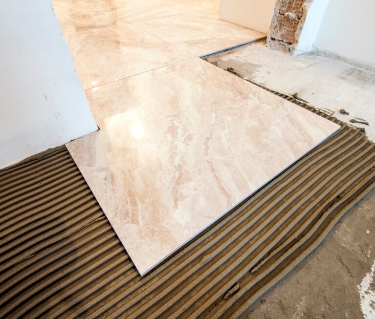 Ceramic tiles and tools for tiler. Floor tiles installation. Home improvement, renovation - ceramic tile floor adhesive, mortar, level