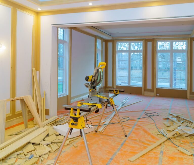 Construction remodeling home with close up of circular saw cutting wood trim molding