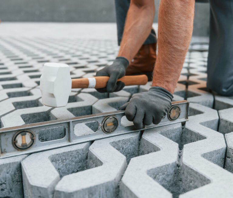 Making of floor. Young man working in uniform at construction at daytime.