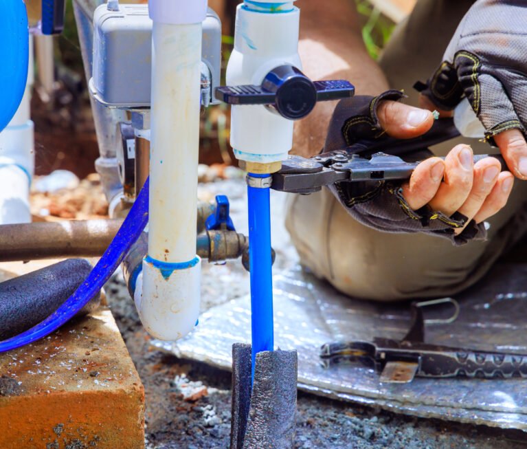 PVC pipe is being connected to water supply artesian well system pump house