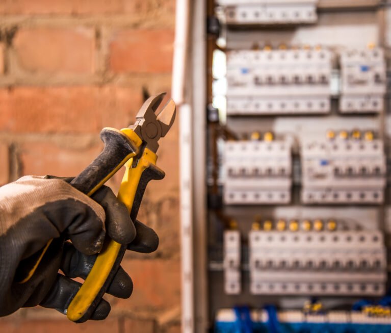 the Assembly of the electrical panel, electrician job, a robot with wires and circuit breakers, tools